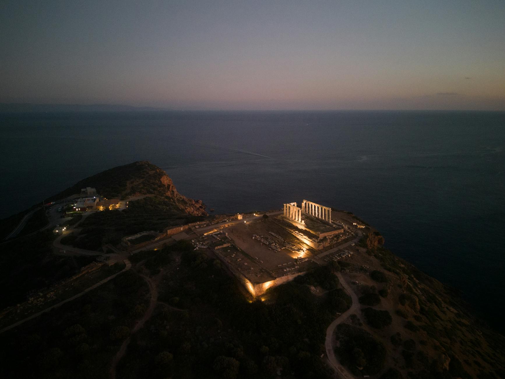 Aerial view of the Temple of Poseidon at Cape Sounion Greece during golden sunset over the Aegean Sea