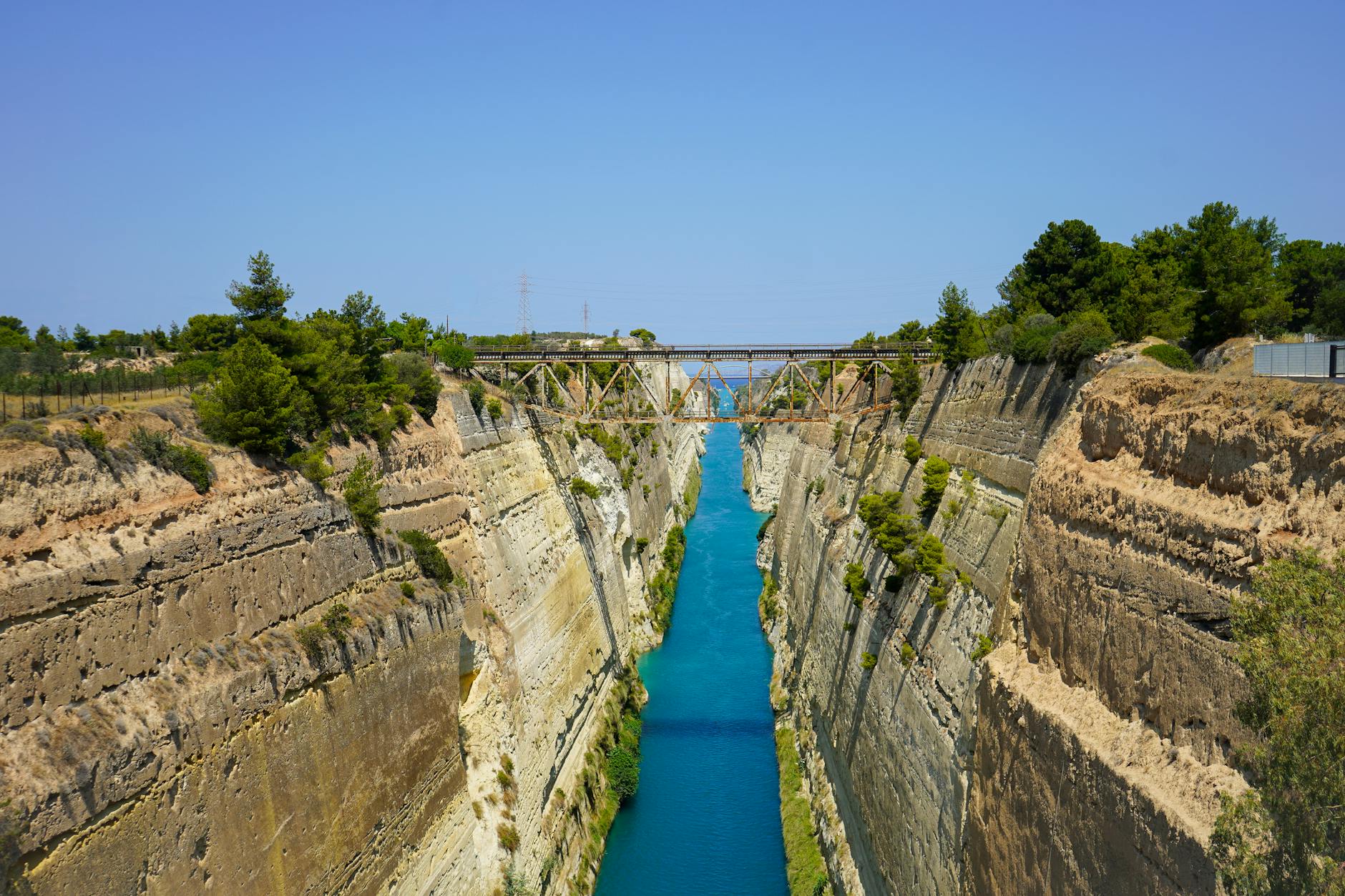 Breathtaking view of the Corinth Canal with blue waters cutting through steep limestone walls Greece