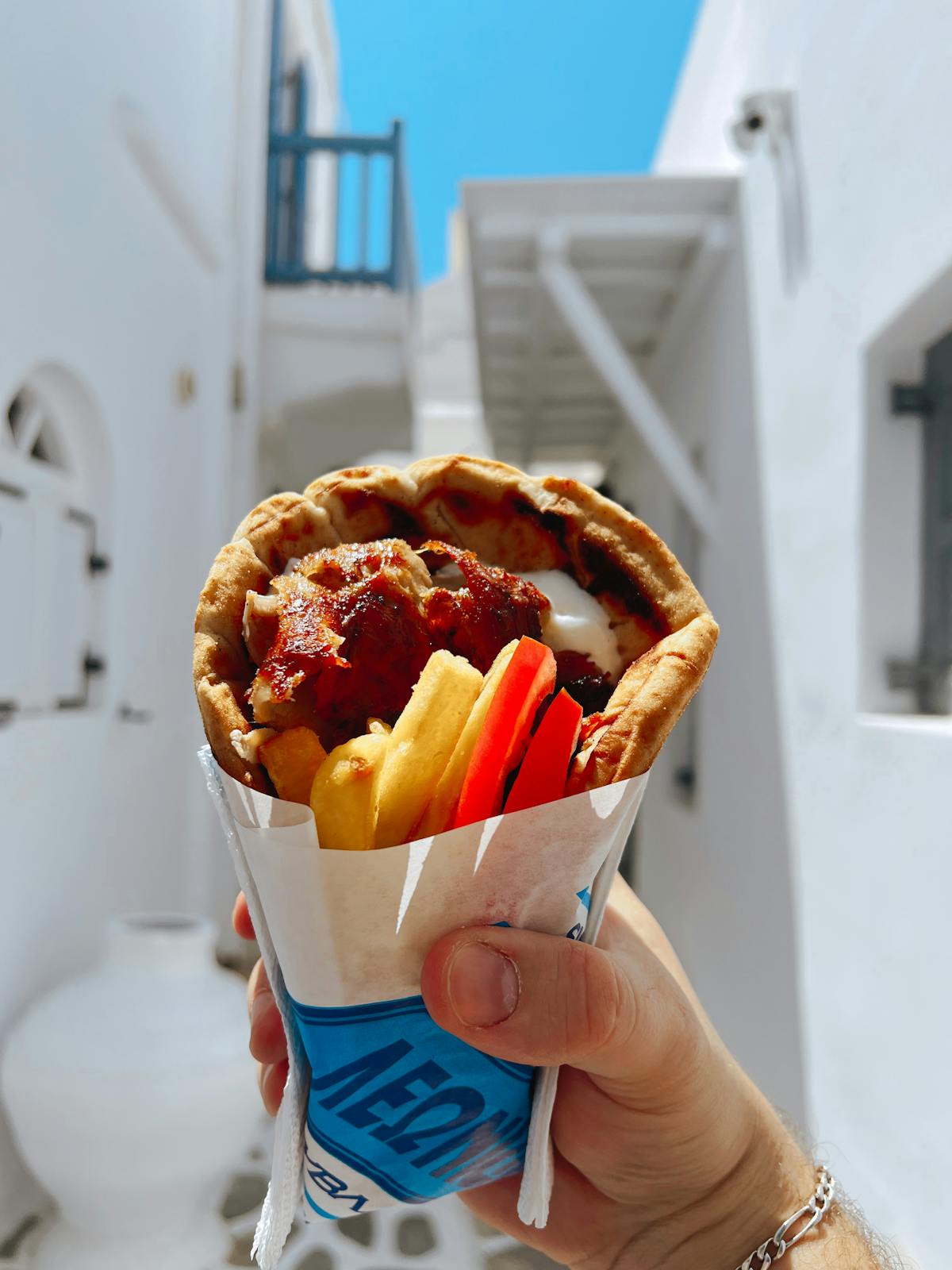 Greek gyro souvlaki wrap held up in an Athens alleyway — Athens food guide