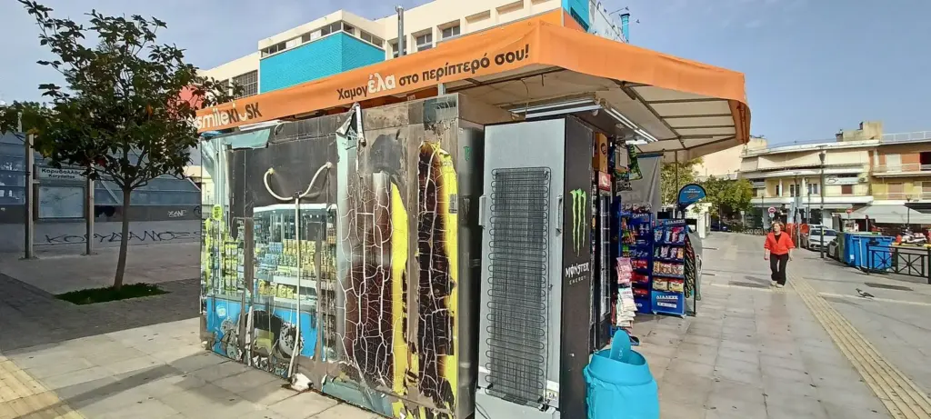 Street kiosk in Athens with an orange awning, drinks fridges and snacks on display
