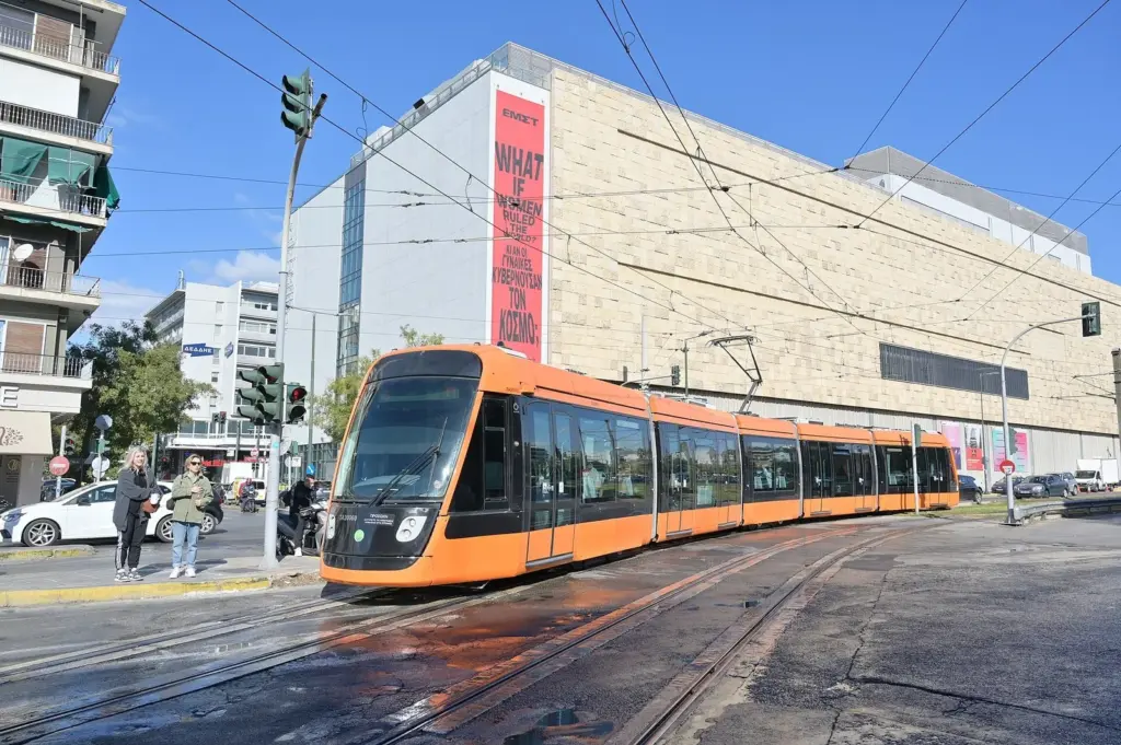 Orange Alstom Citadis tram crossing a junction in Athens