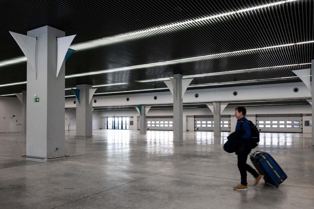 Traveller walking through an airport arrivals hall with luggage