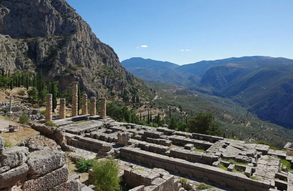 Foundations of the Temple of Apollo at Delphi with mountains and a wooded valley beyond
