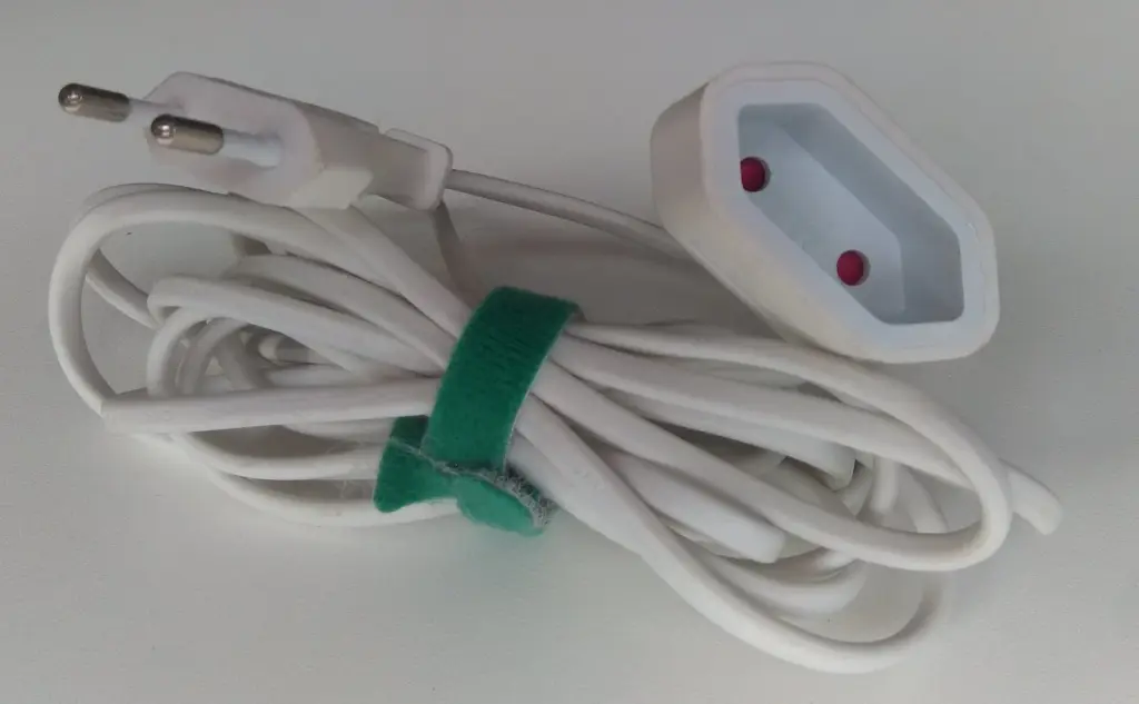 Coiled white extension lead with a two-pin Europlug at one end and a two-hole socket at the other