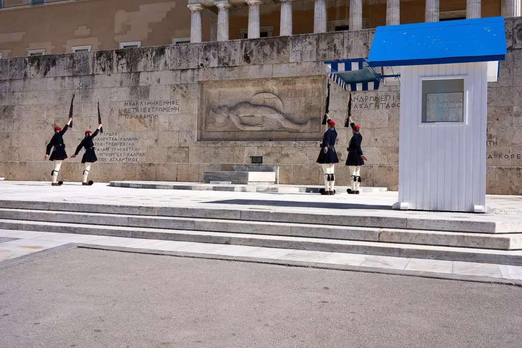 Evzones mid-drill during the changing of the guard in Athens, beside a sentry box at the Tomb of the Unknown Soldier