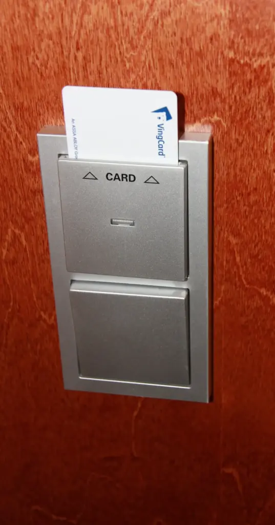 Hotel key card inserted in a wall-mounted holder that switches on the room's power