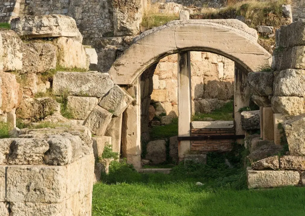 Stone arch and ancient walls among the grass at the Kerameikos in Athens