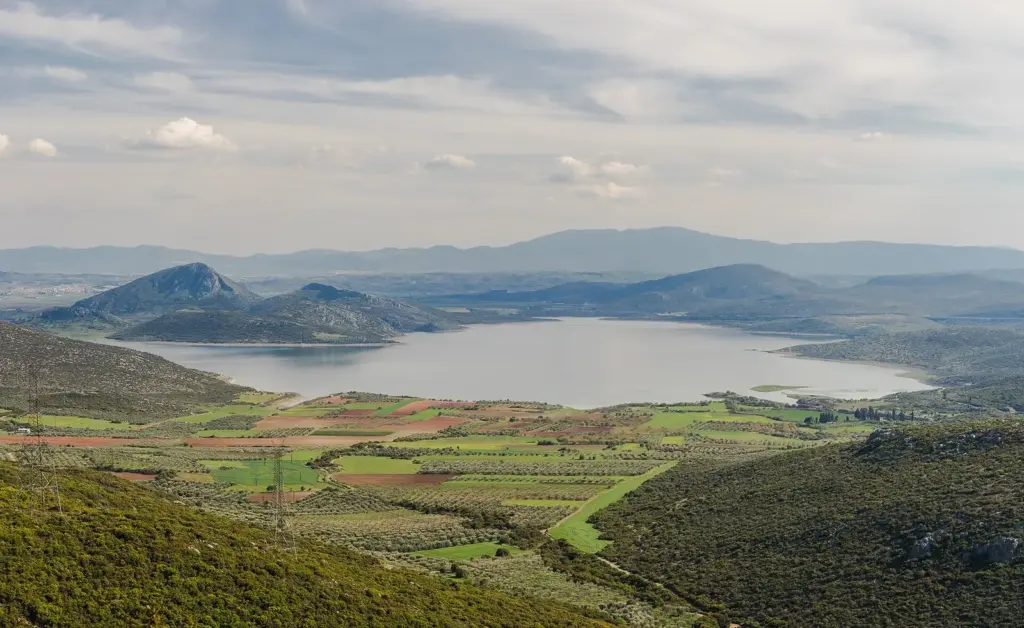 Lake Yliki in Boeotia seen from a hillside above green fields, one of the reservoirs behind Athens tap water