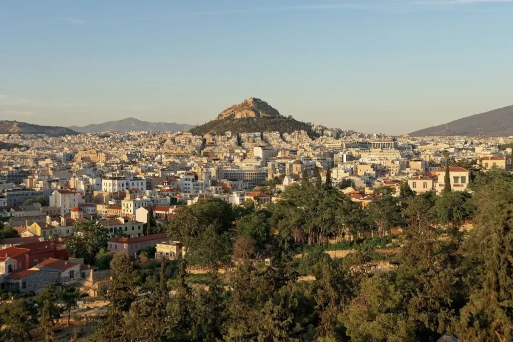 Lycabettus Hill rising above the rooftops of central Athens in evening light, seen from the Areopagus