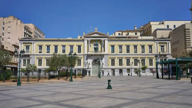 Neoclassical head office of the National Bank of Greece on Aiolou Street in central Athens under a blue sky