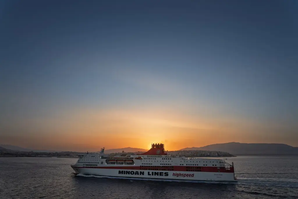 A Minoan Lines ferry sailing out of Piraeus harbour at sunset