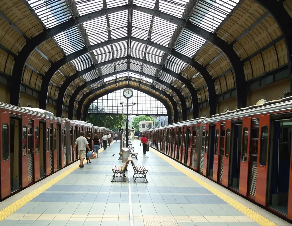 Line 1 trains at the platforms of Piraeus station under its arched iron-and-glass roof