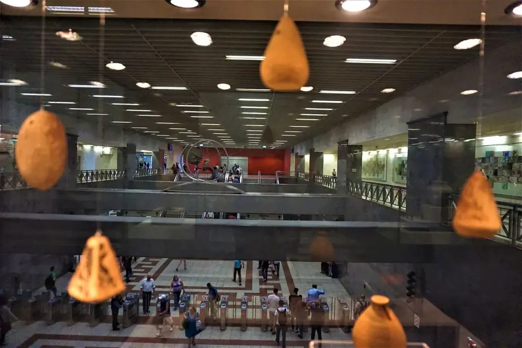 Ancient pottery in a glass display case above the ticket gates at Syntagma metro station